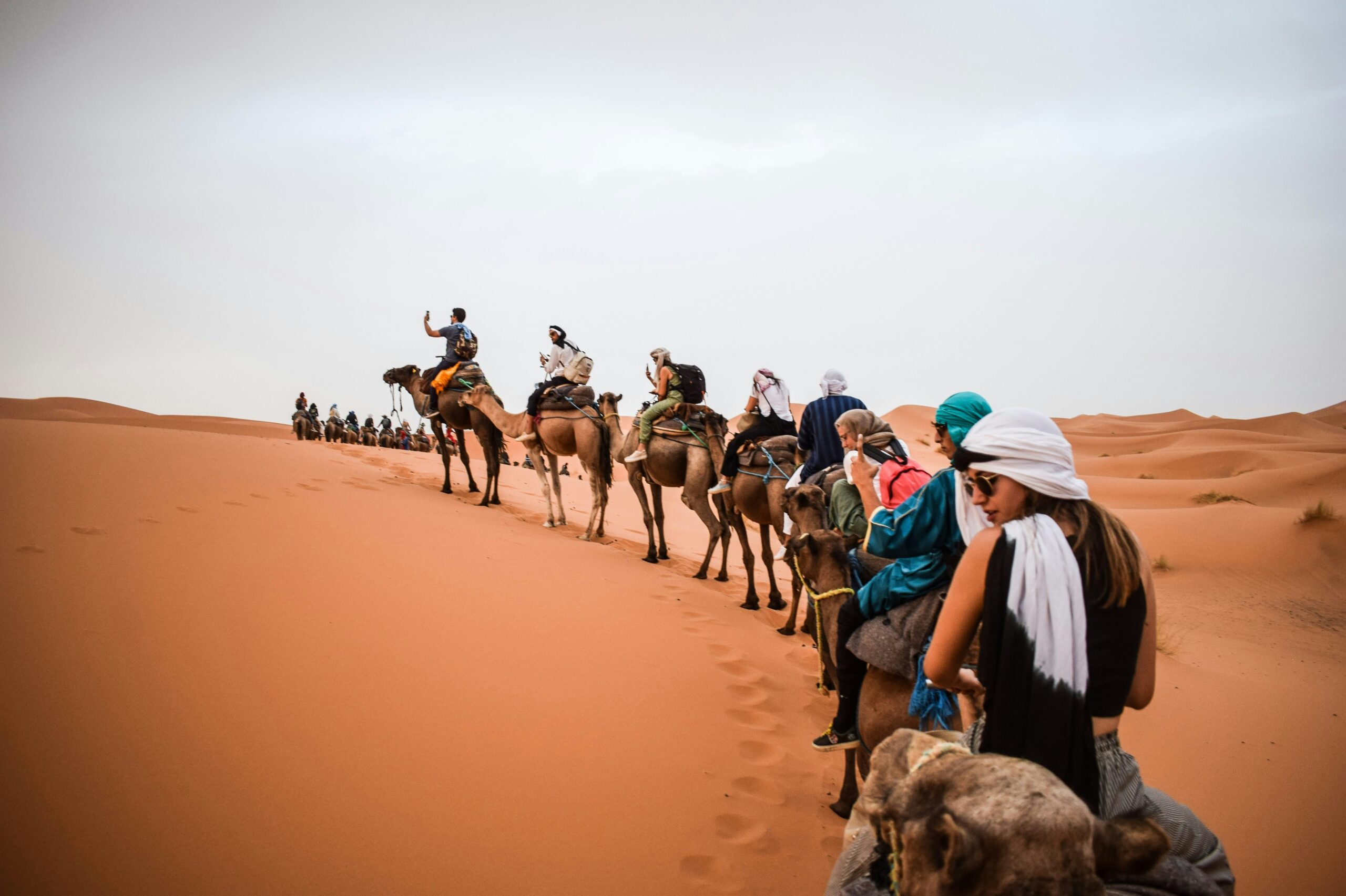 Sahara Desert travel guide: camel trekking caravan tourists Erg Chebbi Morocco dunes