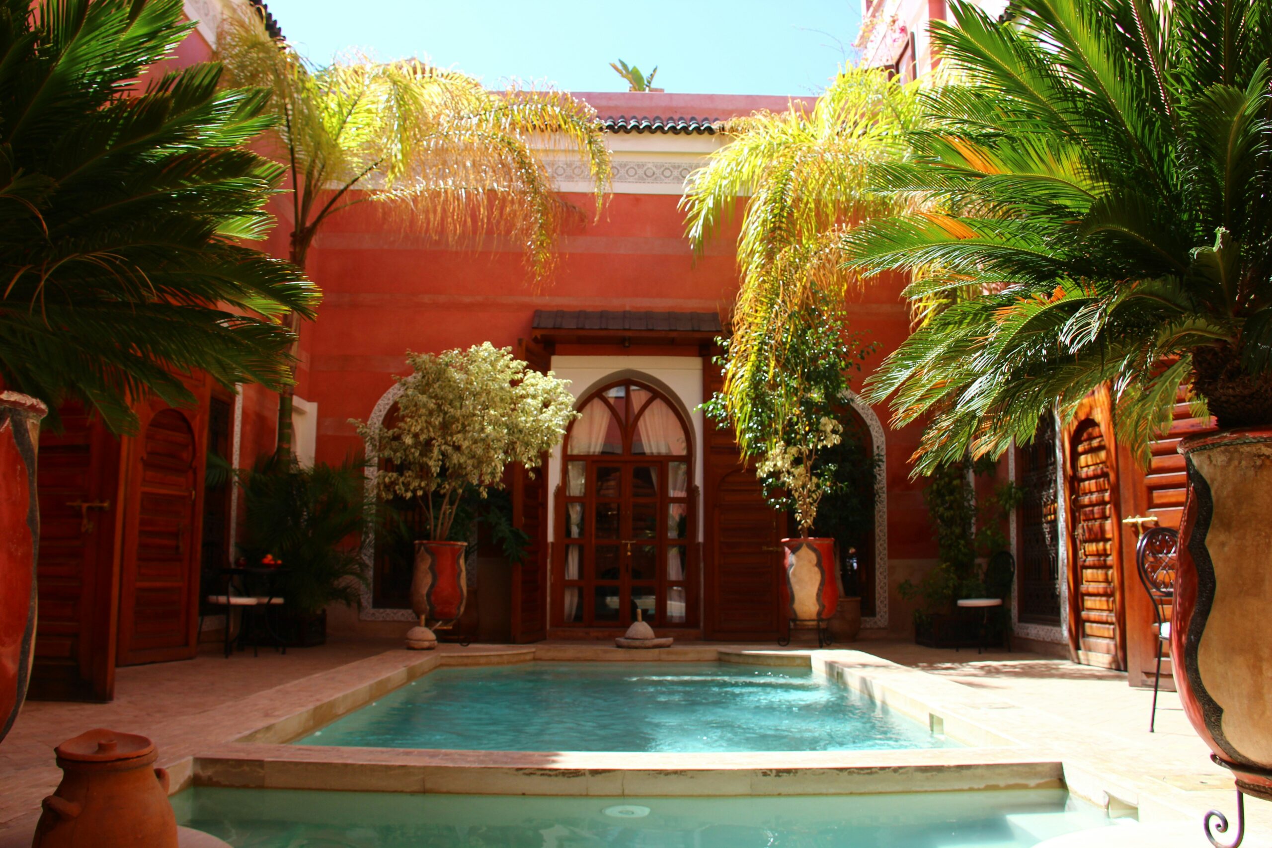Marrakech travel guide: traditional riad courtyard with pool palm trees Morocco