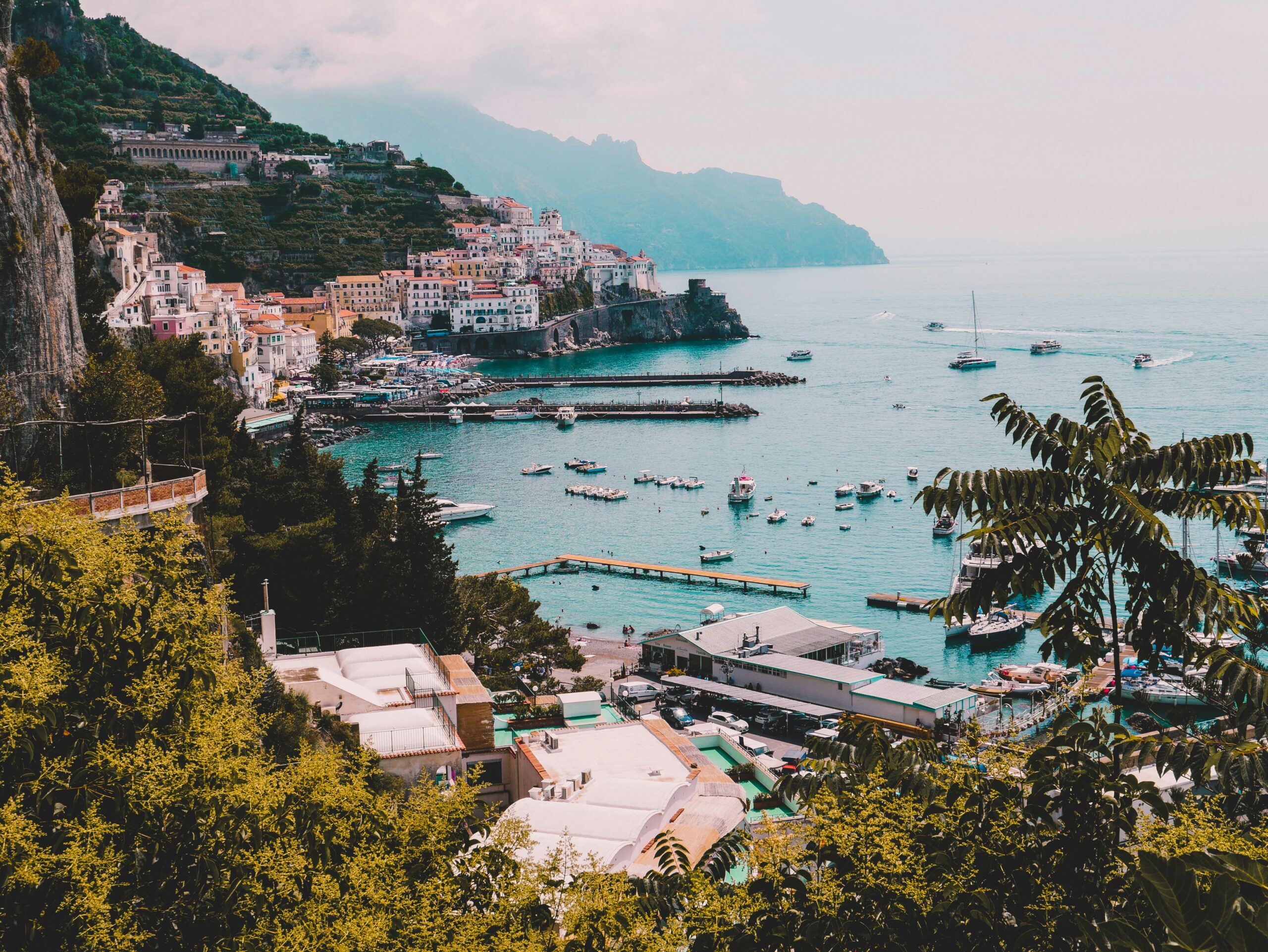 Amalfi Coast travel guide: Amalfi town harbor boats turquoise sea cliff houses Italy
