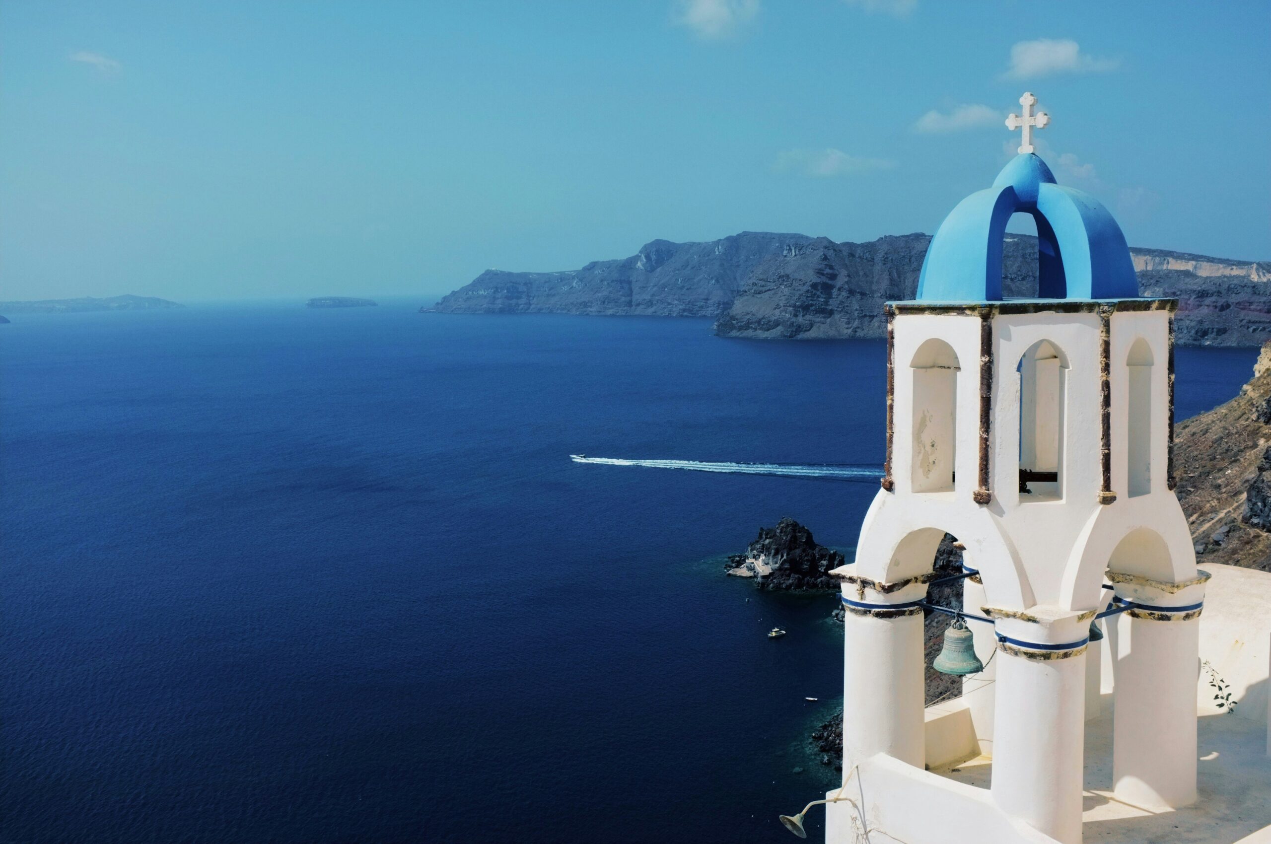 Santorini travel guide: Oia village white houses blue domes caldera cliff Aegean sea